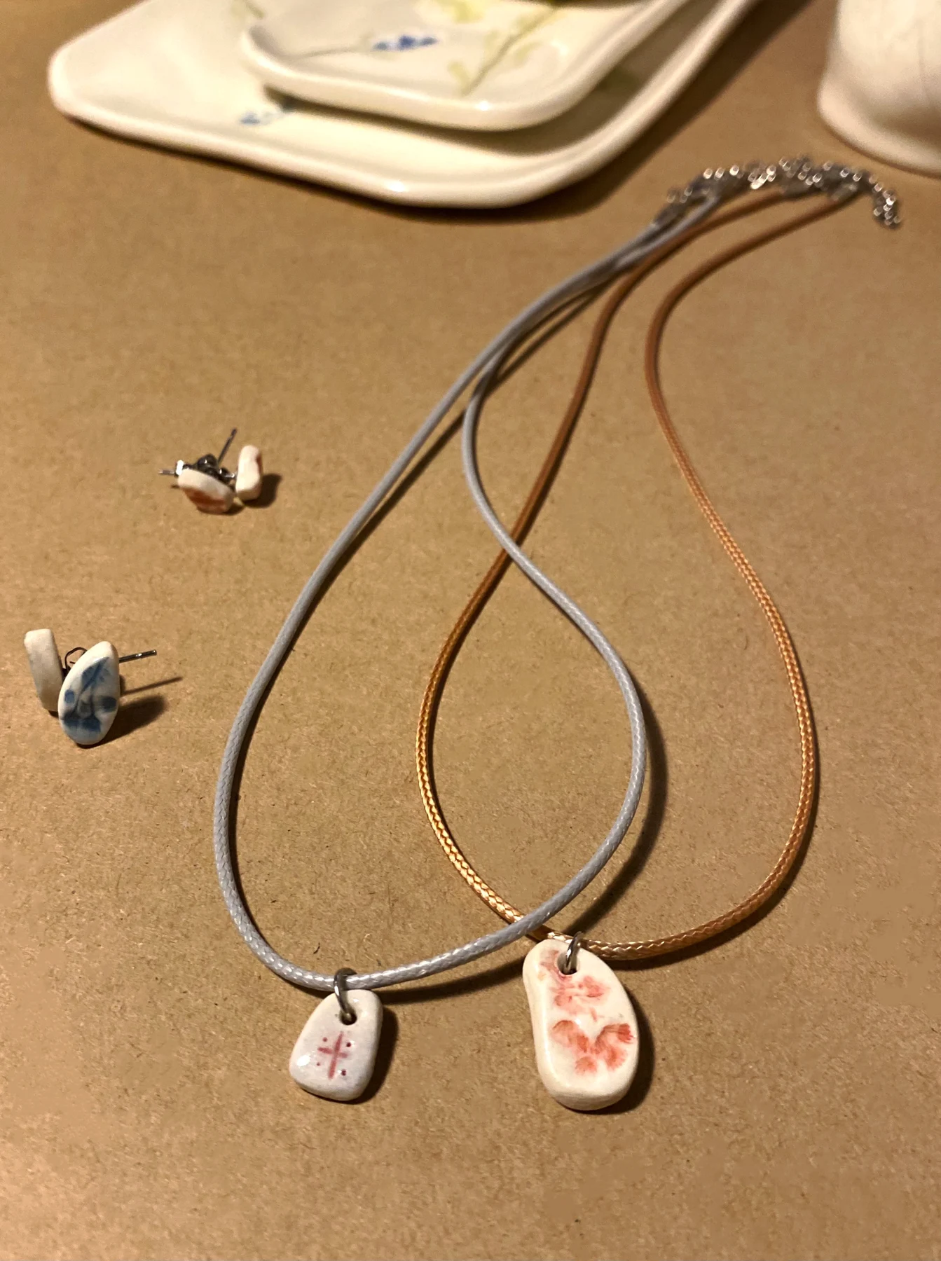Ceramic pendant necklaces and small earrings displayed together