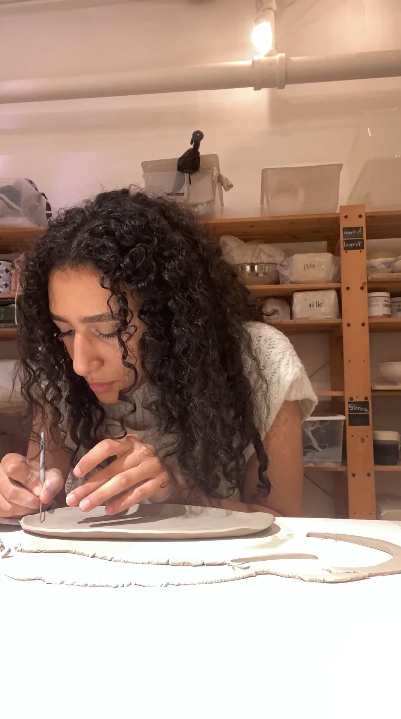 Verina Daoud working carefully on a ceramic piece
