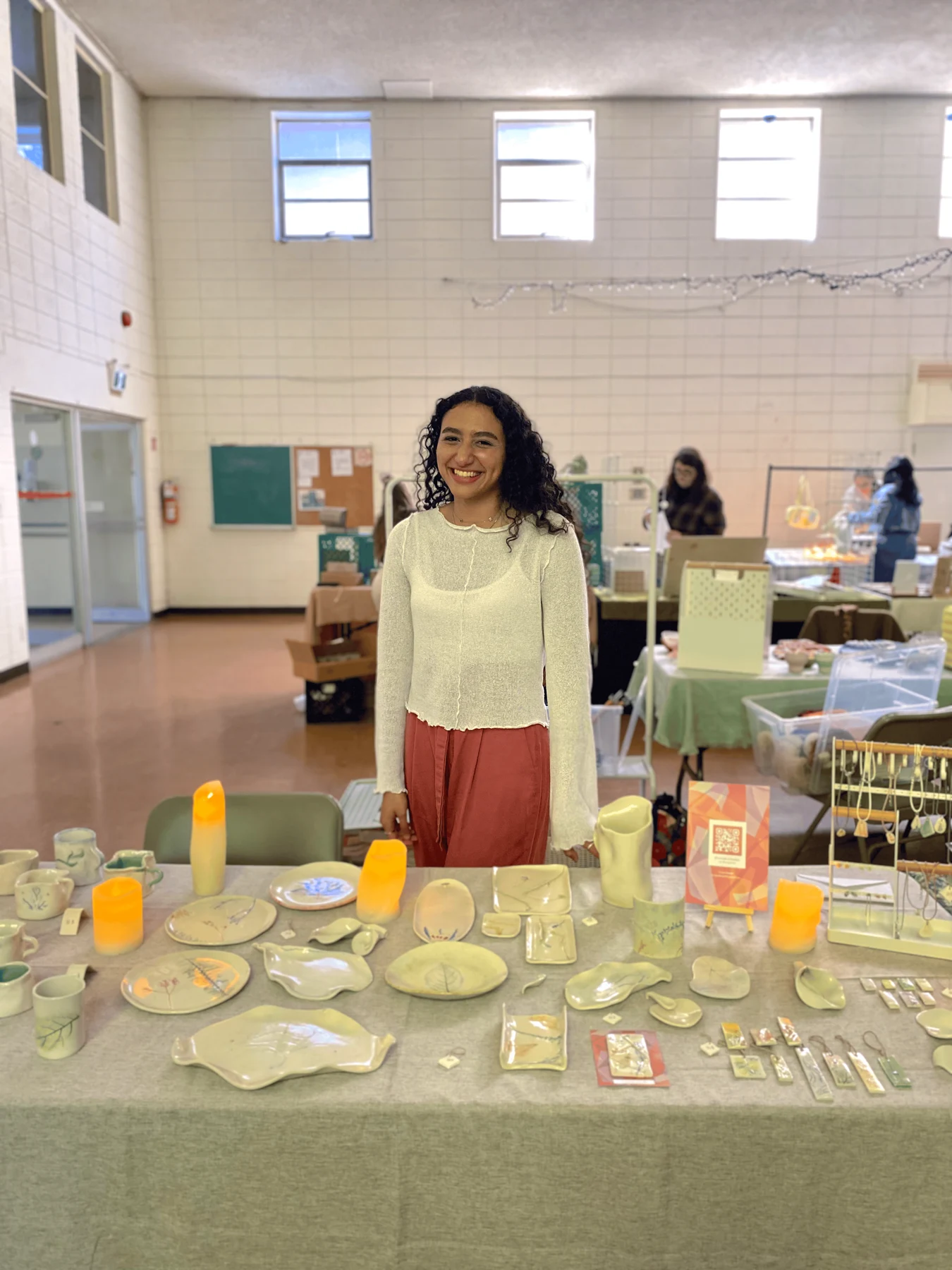 Verina Daoud standing behind a display of her ceramics